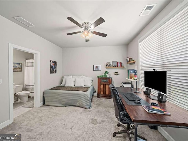 carpeted bedroom featuring ceiling fan, baseboards, ensuite bathroom, and visible vents