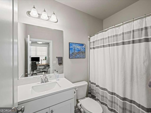 bathroom featuring toilet, vanity, and a shower with curtain
