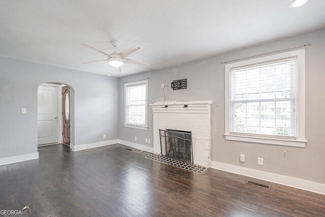 unfurnished living room with ceiling fan, arched walkways, visible vents, and baseboards