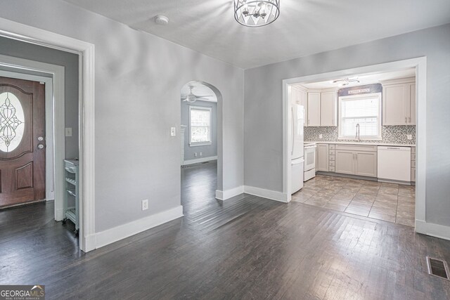 entrance foyer featuring baseboards, wood finished floors, and a wealth of natural light