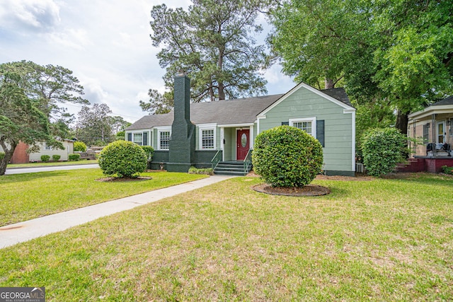 ranch-style house with a front yard and a chimney
