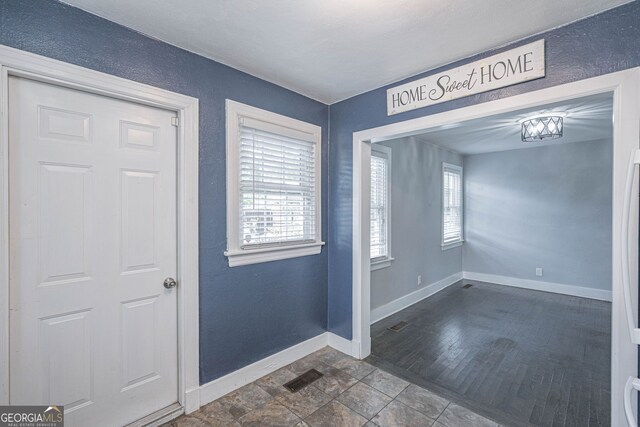 foyer entrance featuring visible vents and baseboards