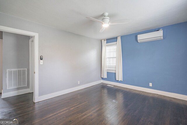 spare room featuring dark wood-style flooring, baseboards, visible vents, a wall mounted air conditioner, and a ceiling fan