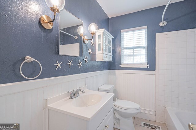 bathroom featuring tile patterned floors, visible vents, toilet, vanity, and wainscoting