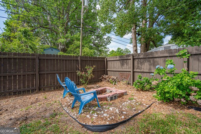 view of yard with a fenced backyard and an outdoor fire pit