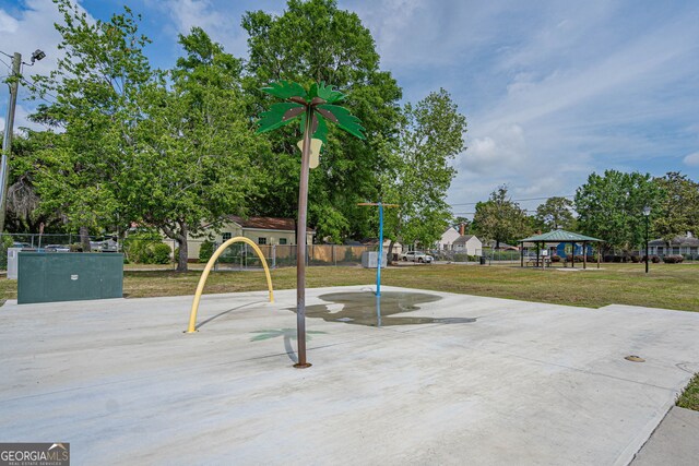 view of property's community featuring a gazebo, a lawn, and fence