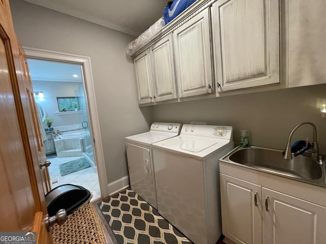 laundry room with cabinet space, tile patterned flooring, washer and dryer, and a sink