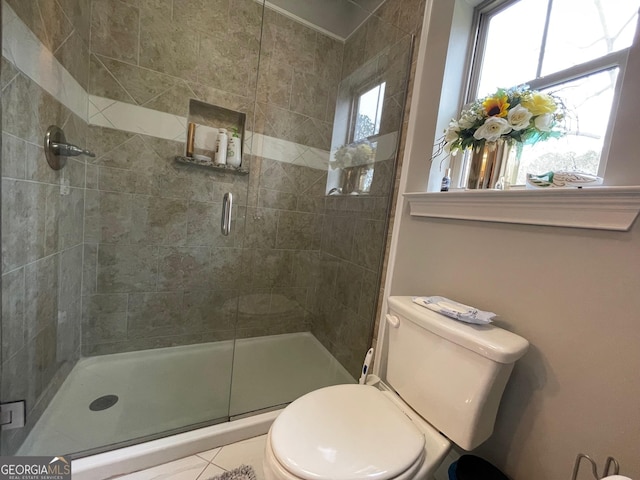 full bath with a shower stall, toilet, and tile patterned flooring