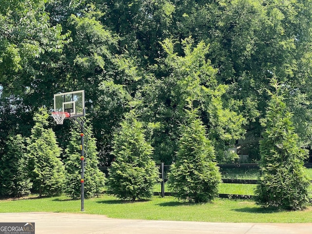 view of sport court with fence and basketball hoop