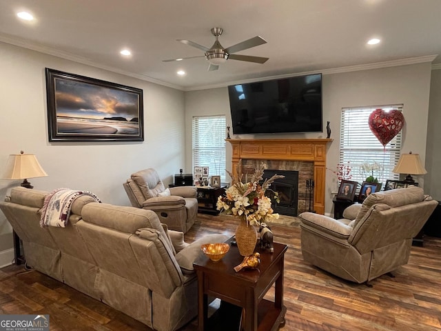 living room with dark wood finished floors, a fireplace, a ceiling fan, and a healthy amount of sunlight