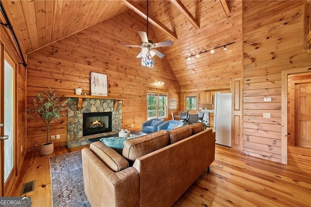 living area featuring wood ceiling, wooden walls, visible vents, and light wood finished floors