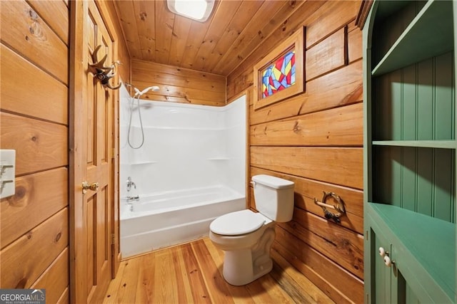 full bathroom with toilet, wood finished floors,  shower combination, wood ceiling, and wood walls