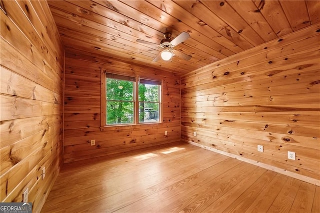 unfurnished room with wooden ceiling, wooden walls, light wood-style floors, and ceiling fan