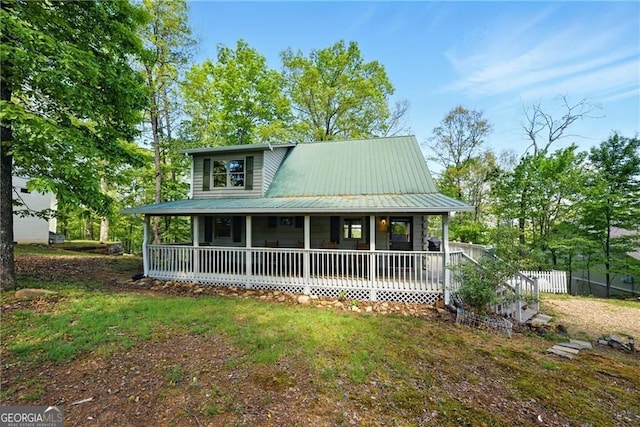 farmhouse inspired home featuring fence, a porch, and metal roof