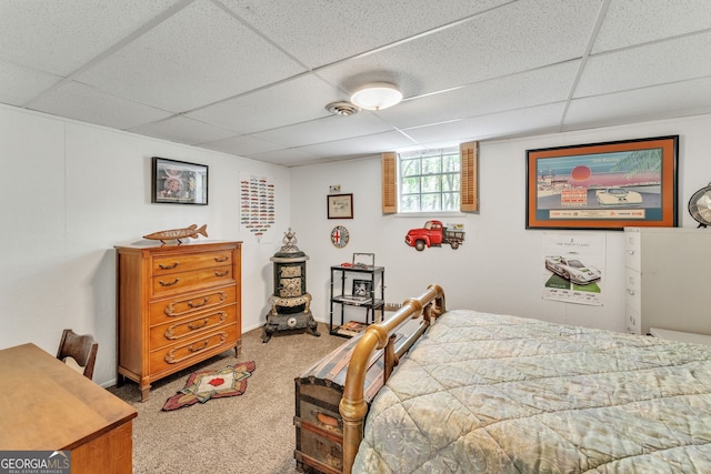 bedroom featuring a drop ceiling and carpet flooring