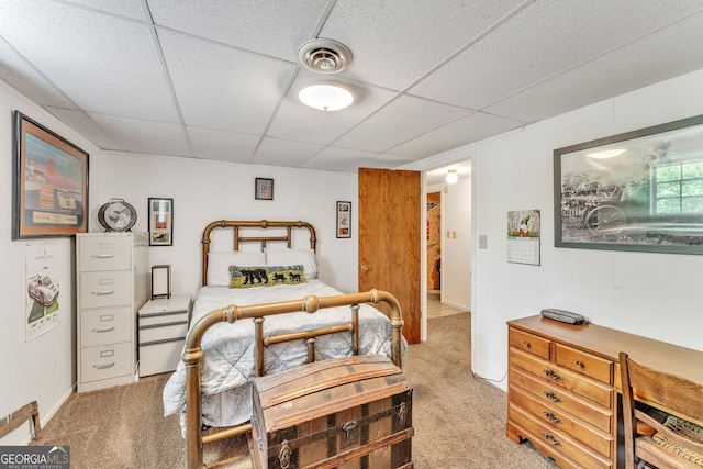 bedroom with light colored carpet, a drop ceiling, and visible vents