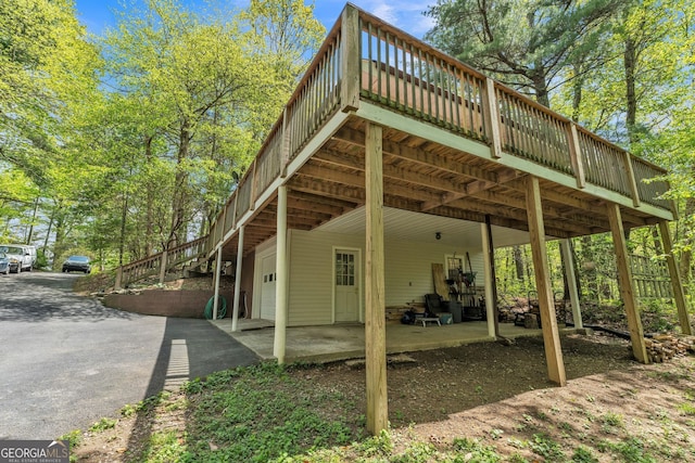 exterior space featuring stairway, a deck, and driveway