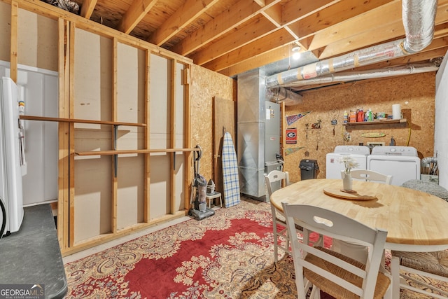 unfinished basement featuring freestanding refrigerator and washing machine and dryer