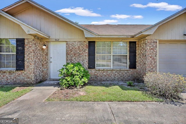 767 Madison Dr, Hinesville, GA 31313 - property entrance featuring brick siding, roof with shingles, and a garage