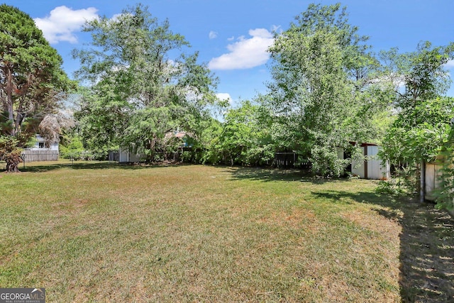 767 Madison Dr, Hinesville, GA 31313 - view of yard featuring fence, an outbuilding, and a storage unit