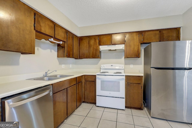 767 Madison Dr, Hinesville, GA 31313 - kitchen featuring under cabinet range hood, light countertops, a sink, light tile patterned flooring, and appliances with stainless steel finishes