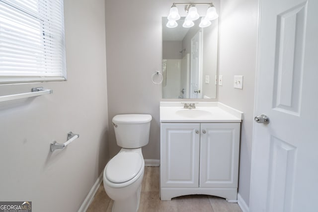 full bath with vanity, baseboards, toilet, and a shower