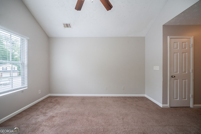 unfurnished room featuring visible vents, carpet floors, lofted ceiling, baseboards, and a ceiling fan