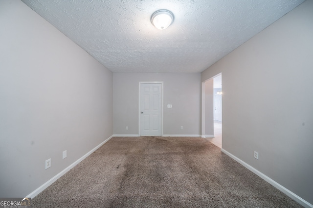 carpeted empty room with baseboards and a textured ceiling