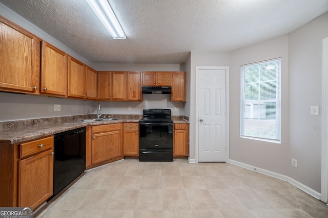 kitchen featuring a sink, ventilation hood, brown cabinetry, and black appliances