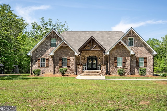 craftsman house with french doors, a shingled roof, brick siding, and a front yard