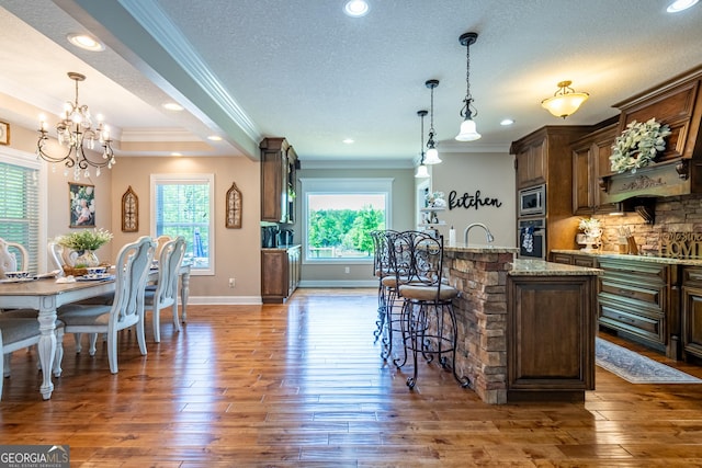 kitchen featuring an inviting chandelier, ornamental molding, plenty of natural light, and appliances with stainless steel finishes