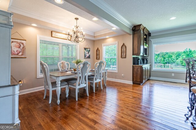 dining space featuring a textured ceiling, a chandelier, recessed lighting, ornamental molding, and hardwood / wood-style flooring