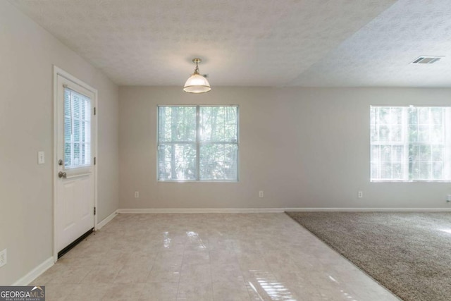 unfurnished dining area featuring a textured ceiling, visible vents, and baseboards