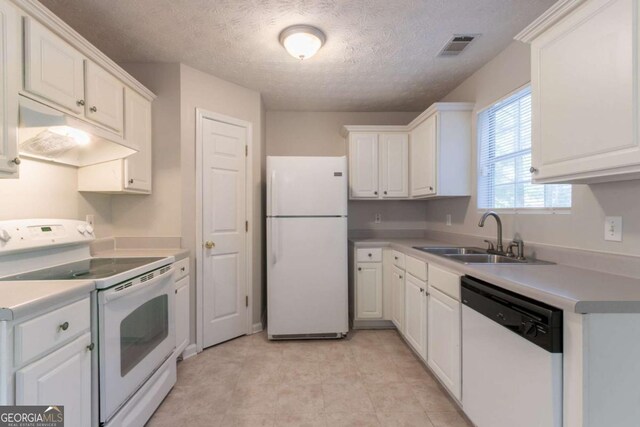 kitchen featuring a sink, white cabinets, a textured ceiling, white appliances, and under cabinet range hood