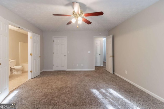 unfurnished bedroom featuring baseboards, ensuite bathroom, and carpet flooring