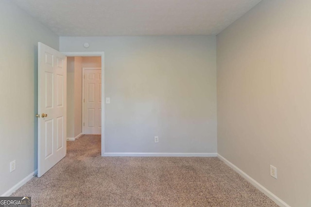 unfurnished room with carpet flooring and baseboards