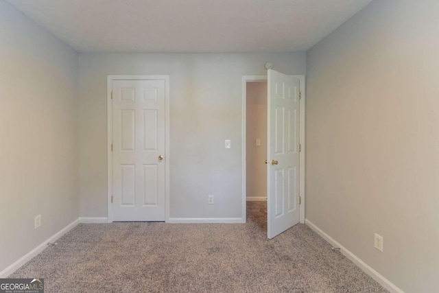 unfurnished bedroom featuring carpet flooring and baseboards