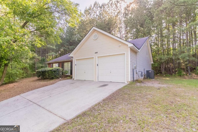 view of property exterior with central AC, a garage, and concrete driveway