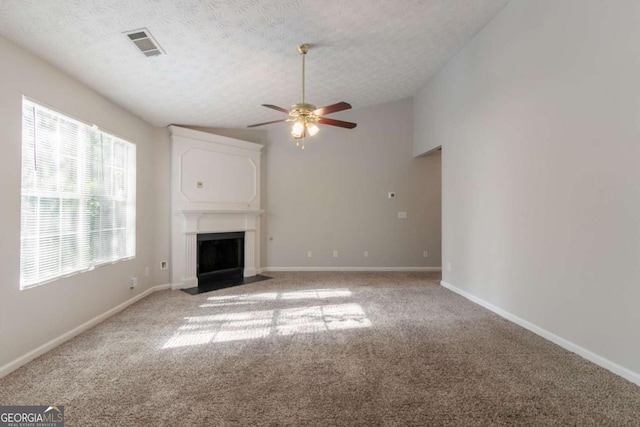 unfurnished living room featuring light carpet, a textured ceiling, visible vents, ceiling fan, and vaulted ceiling