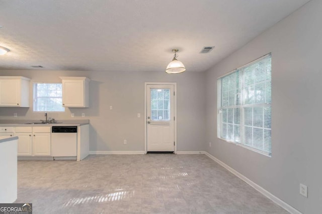 kitchen featuring a sink, visible vents, white cabinetry, white dishwasher, and baseboards
