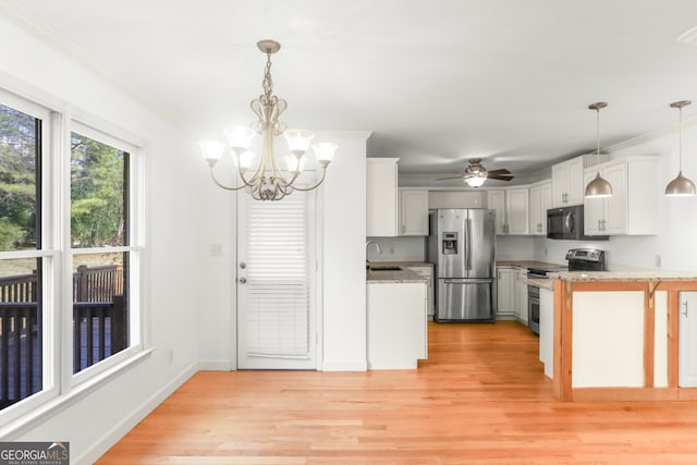 kitchen featuring light wood finished floors, stainless steel appliances, light stone countertops, and white cabinetry