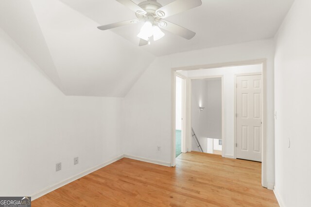 bonus room featuring light wood-type flooring, a ceiling fan, baseboards, and lofted ceiling