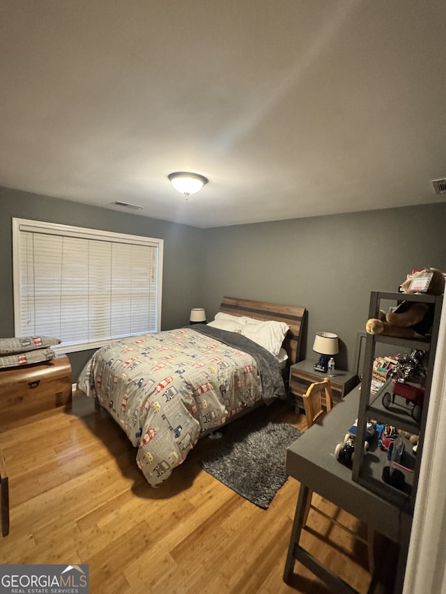 bedroom with wood finished floors and visible vents
