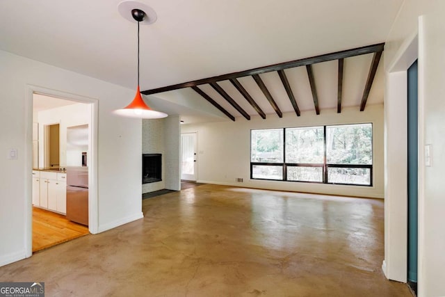 interior space featuring concrete flooring, a fireplace, baseboards, and lofted ceiling with beams