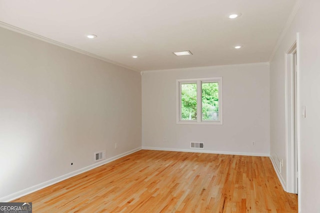 unfurnished room featuring crown molding, light wood-style floors, and visible vents