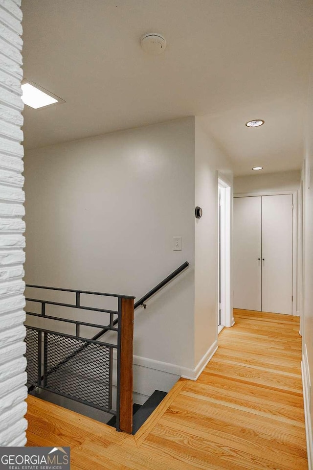 stairway featuring wood finished floors, baseboards, and recessed lighting
