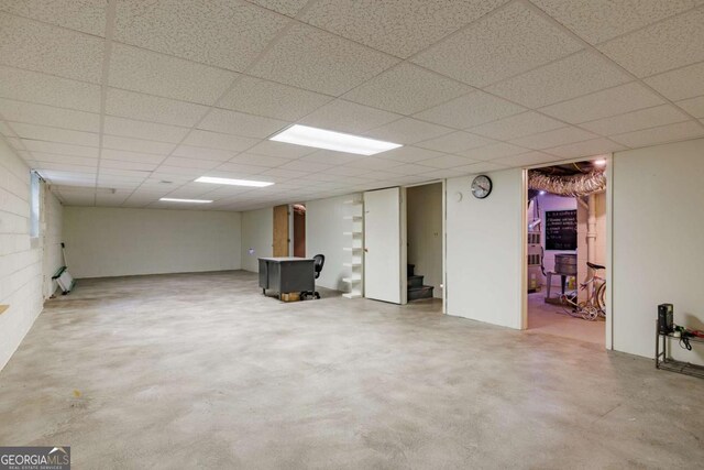 finished basement with a drop ceiling and stairs
