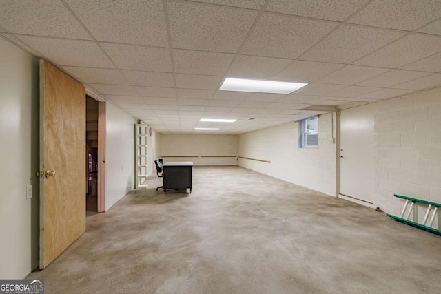 finished below grade area featuring a drop ceiling