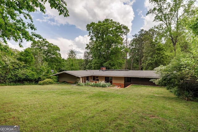 exterior space with a chimney and a front lawn