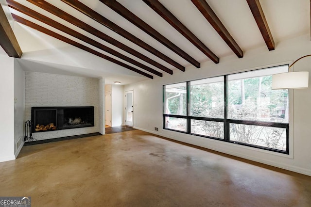 unfurnished living room with lofted ceiling with beams, baseboards, concrete flooring, and a fireplace